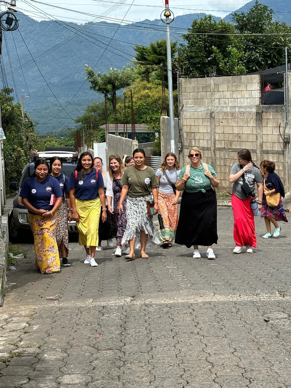 Group of women walking on a street with mountains in the background